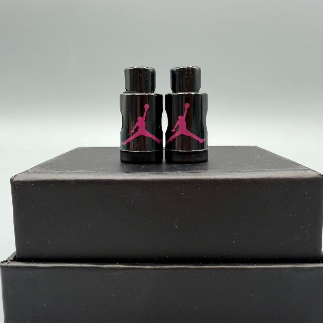Black and pink Jordan lace locks on a black box with a gray background