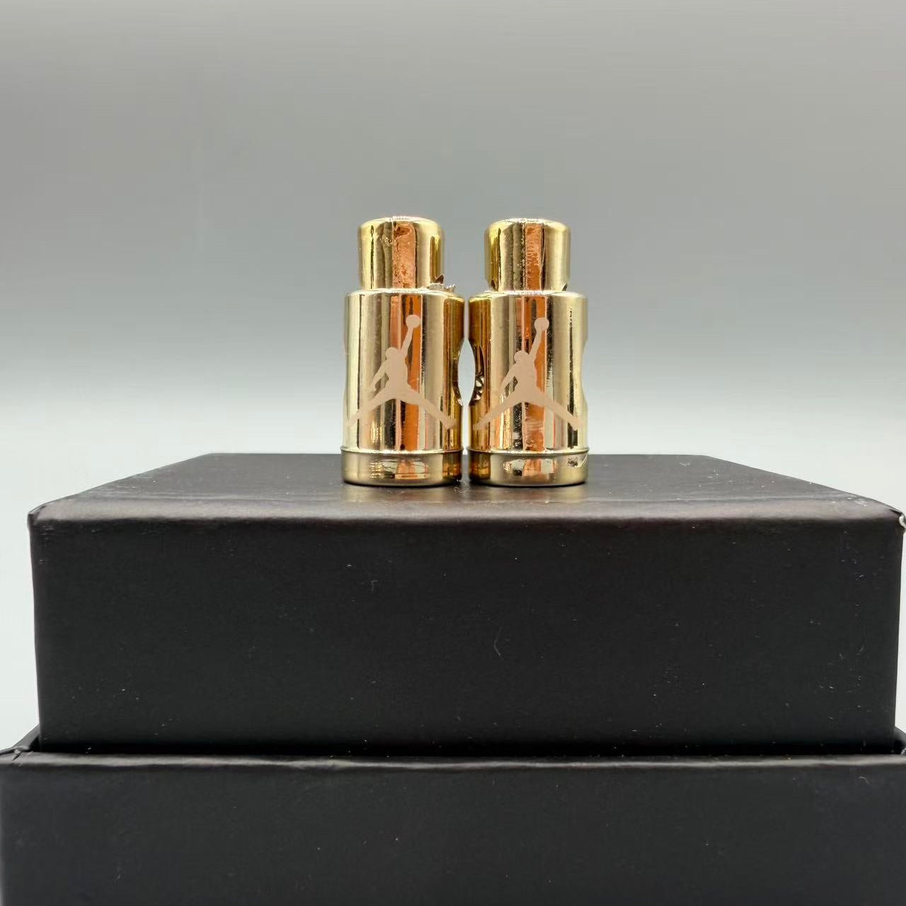 Gold cufflinks on a black box with a gray background