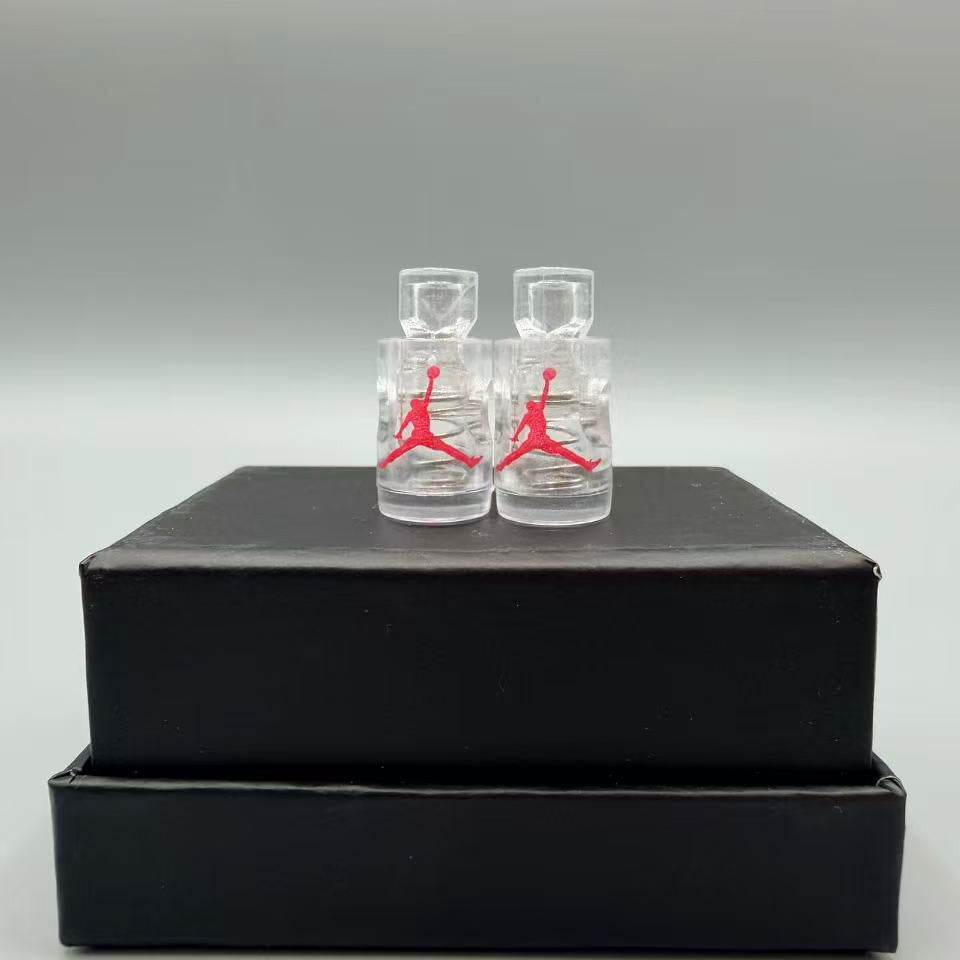 Two clear bottles with red logo on a black box against a gray background