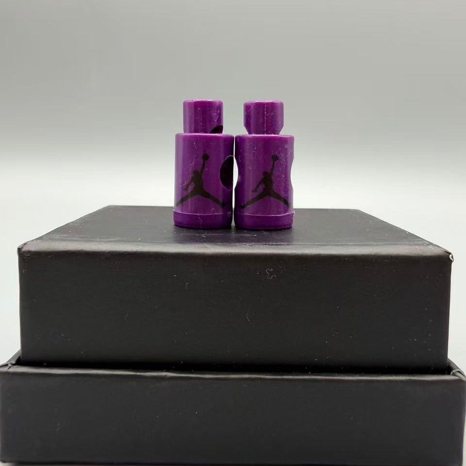 Purple Jordan jumpman lace locks on a black box with a gray background