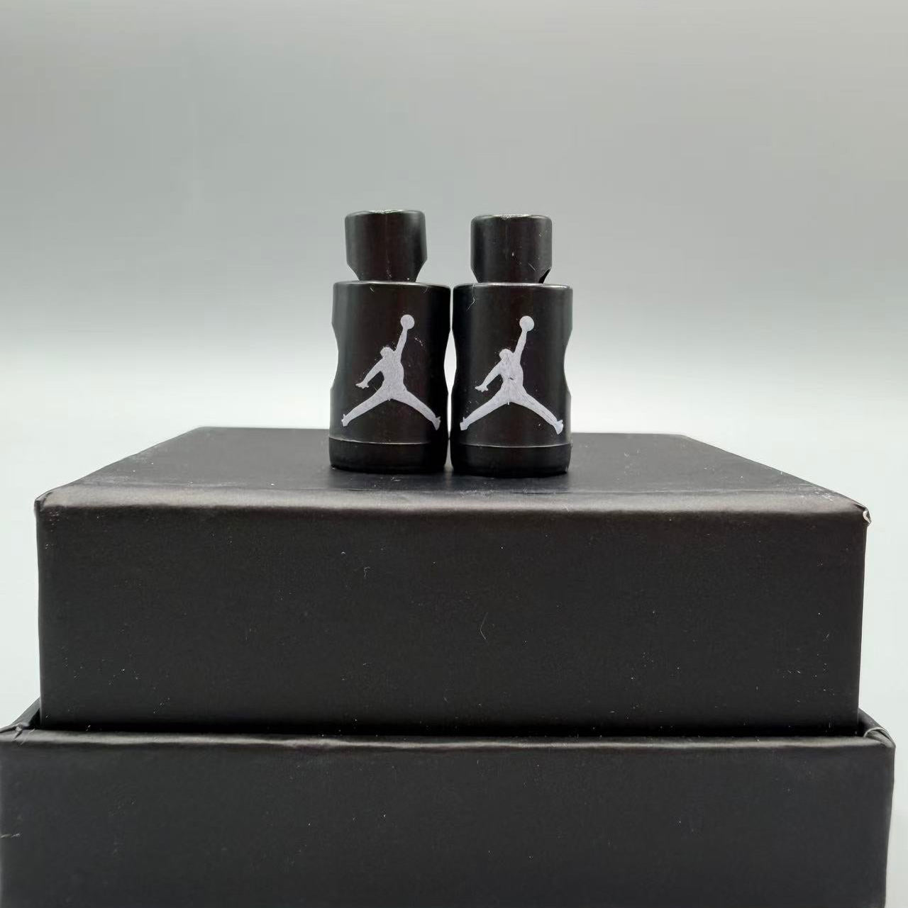 Black and white Jordan logo Lace locks items on a black box with a gray background