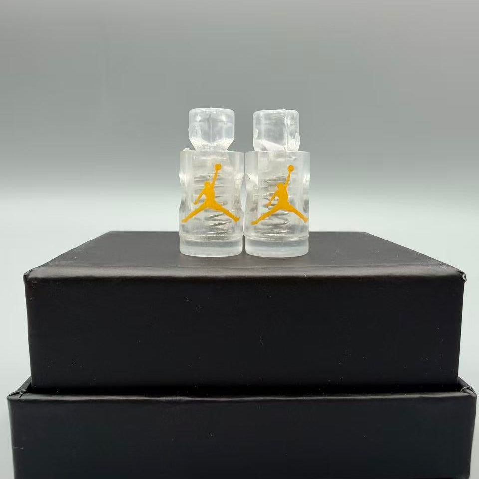 Two clear lace locks with yellow logo on a black box against a gray background