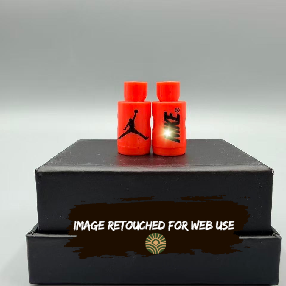 Two red lace locks with black logos on a black box against a gray background
